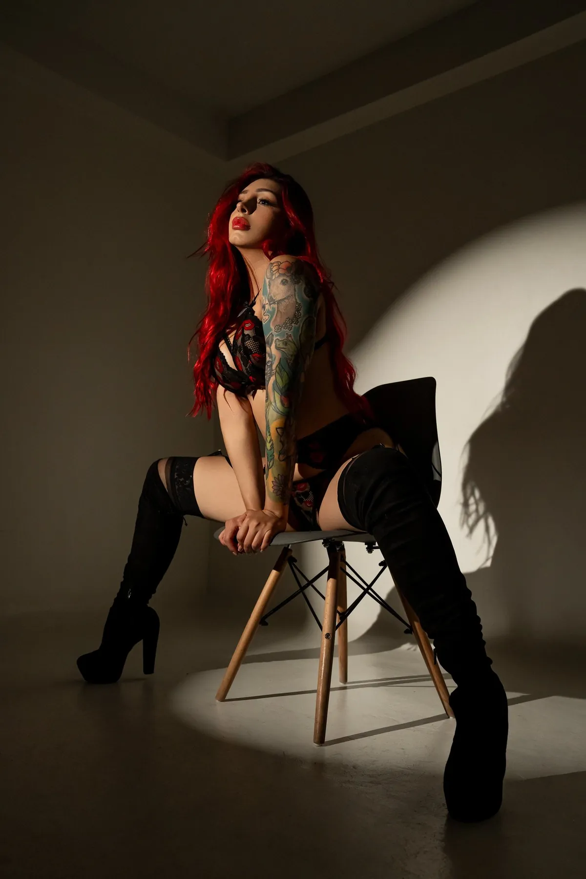 Modelo sentada bajo un foco, con botas altas